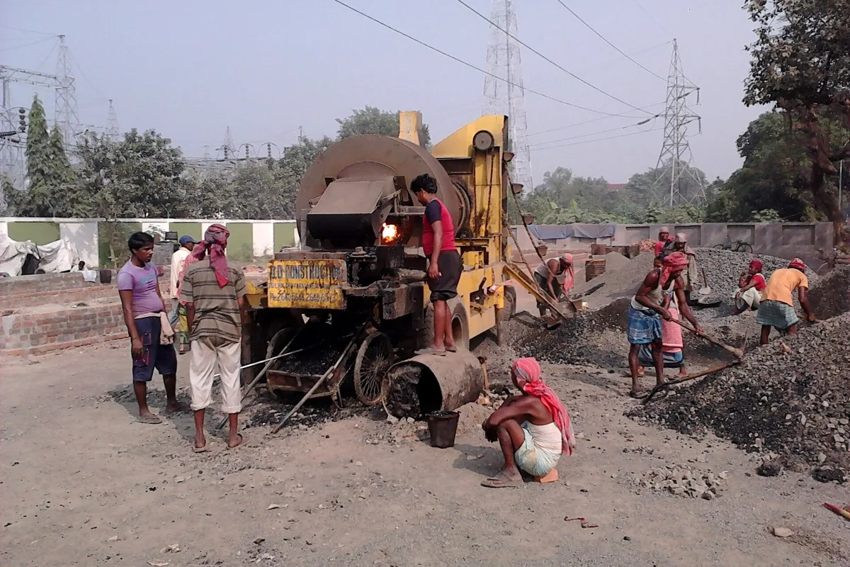 Workers laying hot-mix on a road (representative)