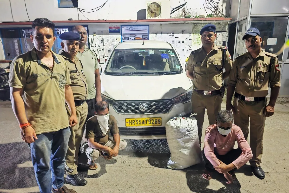 रुद्रपुर कोतवाली में बरामद गांजे और अर्टिगा कार के साथ पुलिस टीम और दोनों आरोपी, आरोपियों के चेहरे ढके