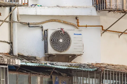 Air-conditioner outdoor unit on a building wall (representative)