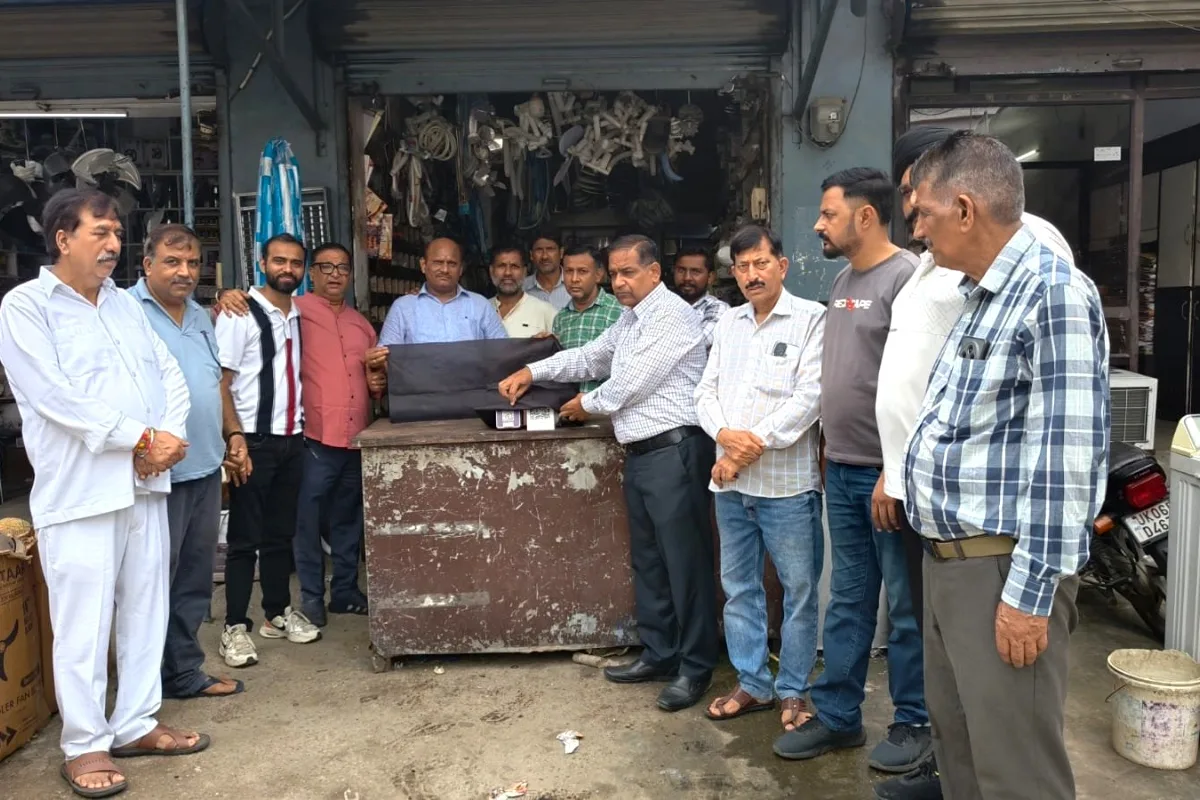 रुद्रपुर में एक दुकान के क्यूआर कोड स्कैनर पर काला कपड़ा डालकर विरोध जताते व्यापार मंडल के व्यापारी