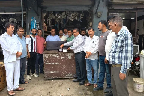 रुद्रपुर में एक दुकान के क्यूआर कोड स्कैनर पर काला कपड़ा डालकर विरोध जताते व्यापार मंडल के व्यापारी