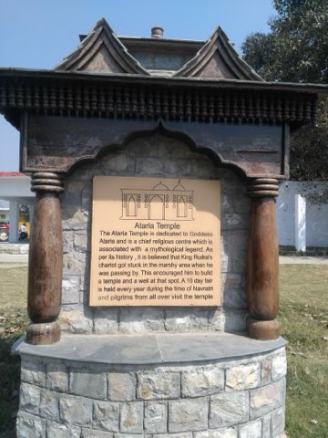 अटरिया मंदिर, रुद्रपुर के परिसर में लगा लकड़ी और पत्थर का सूचना-पट्ट, जिस पर मंदिर का इतिहास लिखा है।