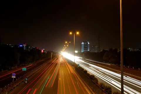 Light trails of vehicles on a highway at night (representative)